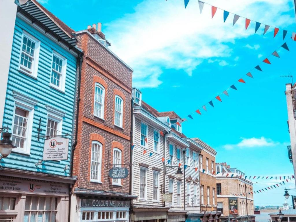 uma fila de edifícios numa rua com bandeiras em Beautiful and modern House in Gravesend em Gravesend