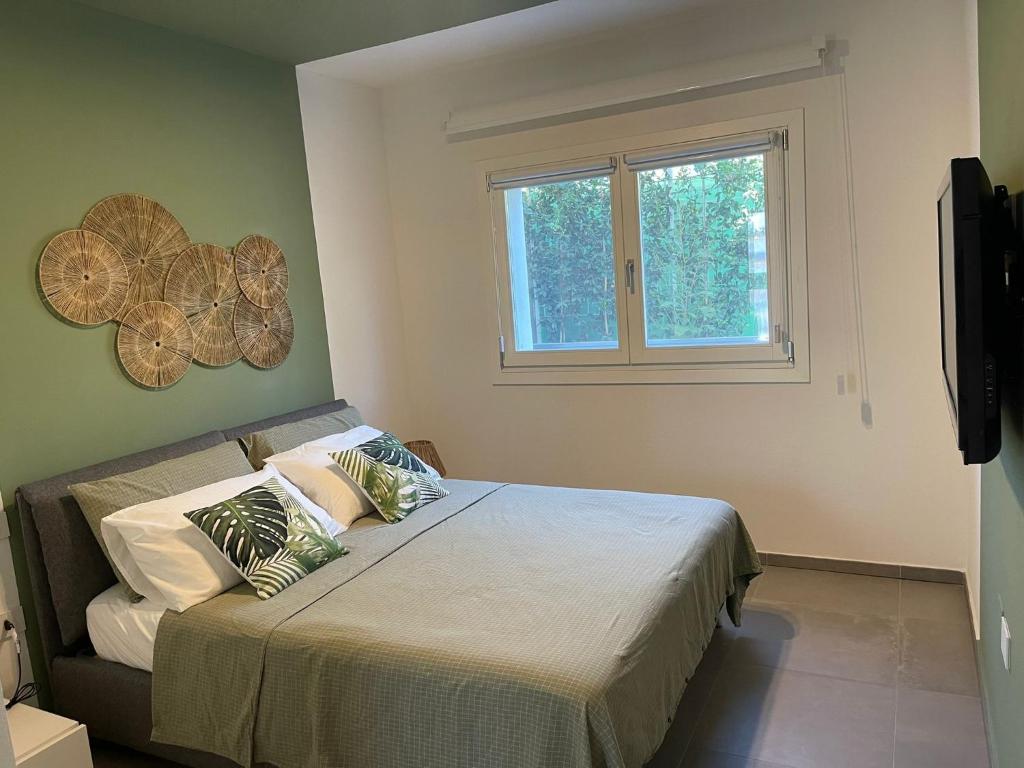 ein Schlafzimmer mit einem Bett mit Kissen und einem Fenster in der Unterkunft LOUXORY ACCOMODATION CAGLIARI in Cagliari