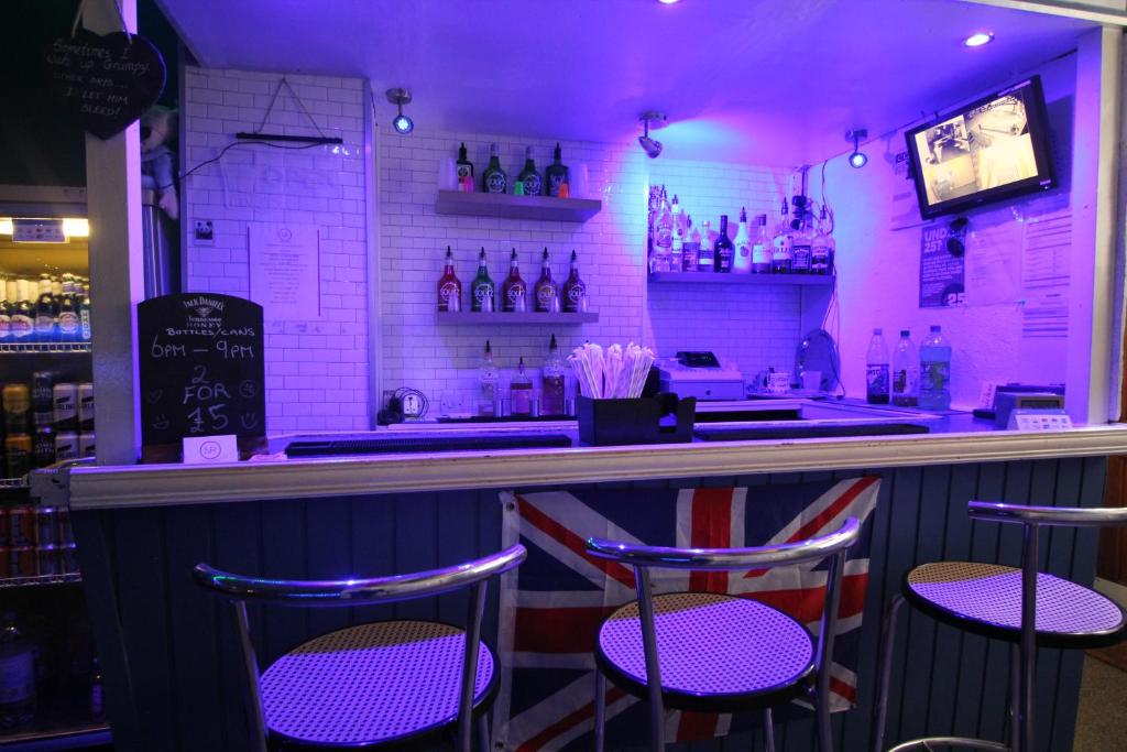 un bar con iluminación púrpura en un restaurante en Jesmond International Hotel, en Blackpool