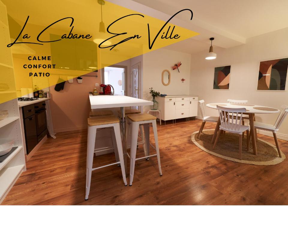 a kitchen and dining room with a table and chairs at La Cabane en Ville in Riom