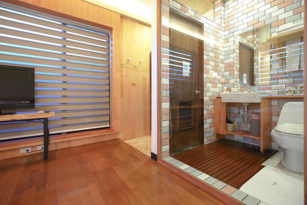 a bathroom with a toilet and a tv and a window at 檜木居民宿 - 立案證號 一六三 - 一六八 - 一七零 in Ji&#39;an