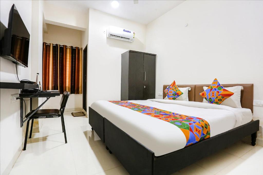 Schlafzimmer mit einem Bett, einem Schreibtisch und einem TV in der Unterkunft FabHotel Destiny 74 in Indore