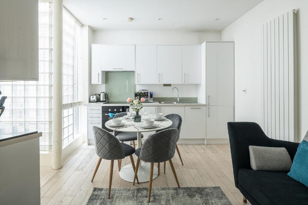 a kitchen and living room with a table and chairs at Fitzrovia - Charlotte Street by Viridian Apartments in London