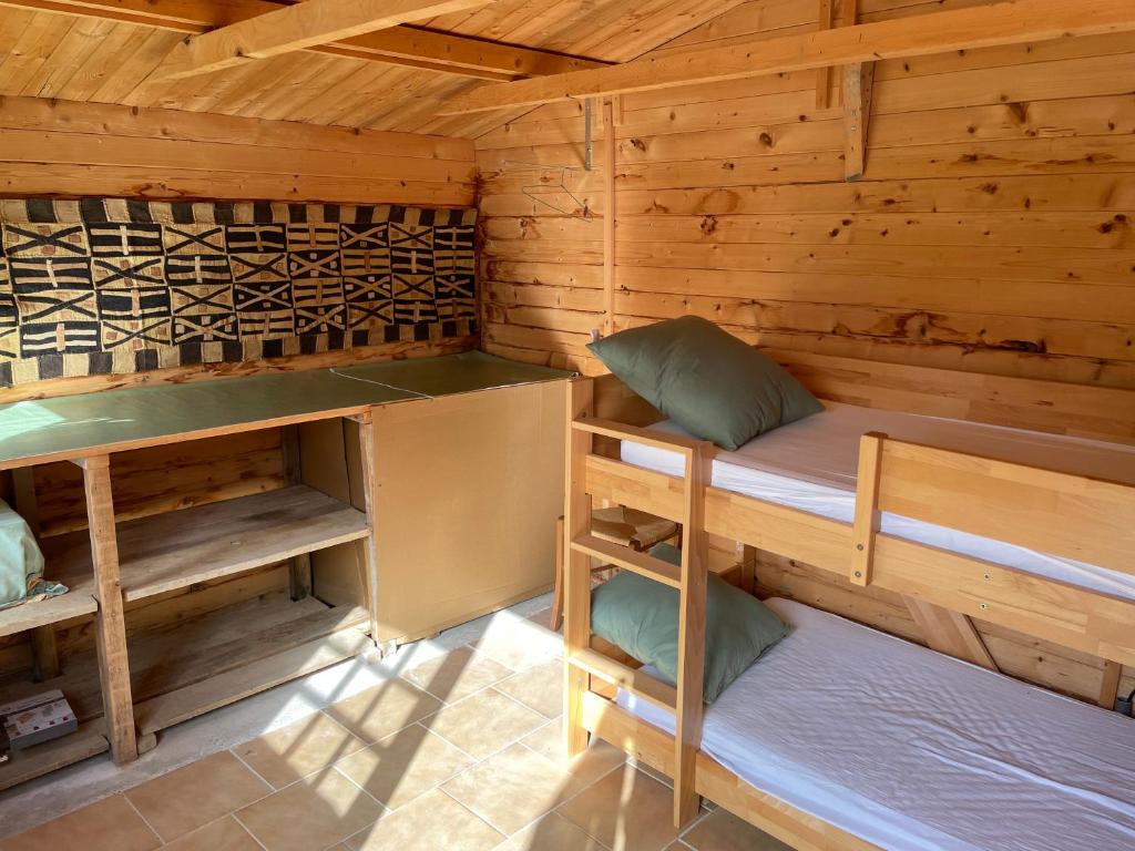 a room with two bunk beds in a wooden cabin at Gîte ylangylang in Saint-Paul-le-Jeune