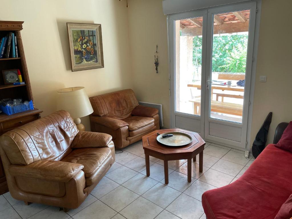 a living room with a couch and chairs and a table at Gîte ylangylang in Saint-Paul-le-Jeune