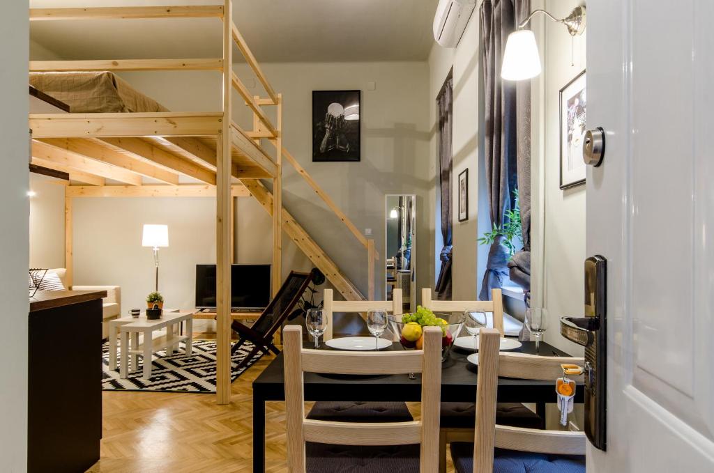 ブダペストにあるSweet Cumin Apartment Next To Famous Cafeのダイニングテーブルとロフトベッドが備わる客室です。