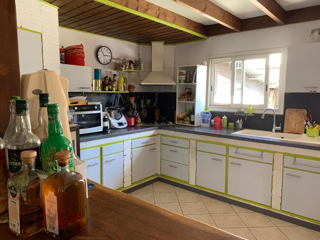 a kitchen with a counter with bottles on it at Le Dodo Salé in Étang-Salé