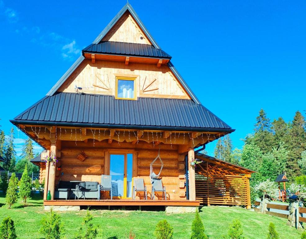 a log cabin with a black roof at Domki w Zębie in Ząb