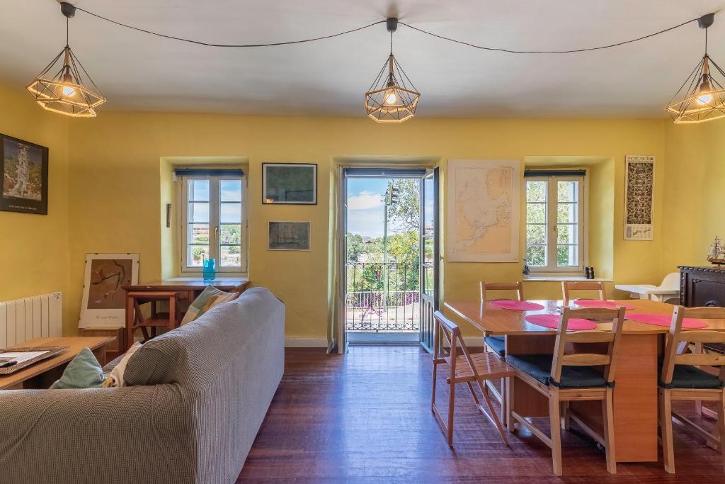 sala de estar con paredes amarillas, mesa y sillas en Antigua casa de escritor junto a la playa en Mundaka