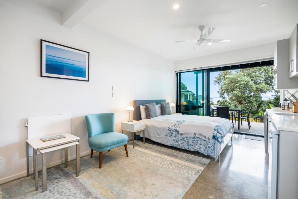 a bedroom with a bed and a table and a chair at Bayview Corner Suite Unit 2 - Paihia Unit in Paihia