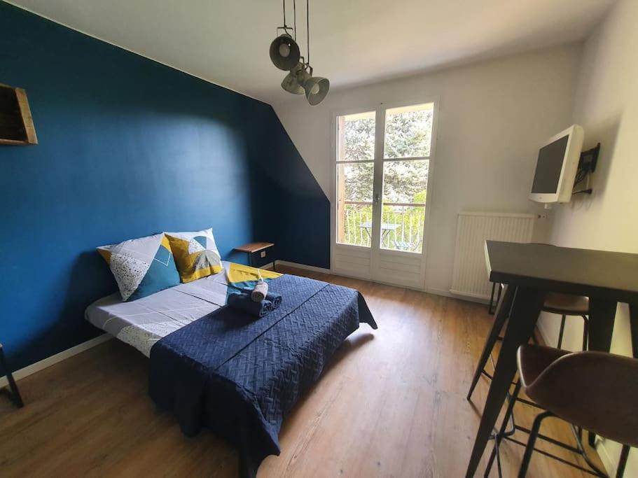 une chambre avec un lit avec un mur bleu dans l'établissement Studio Aix avec stationnement, à Aix-en-Provence
