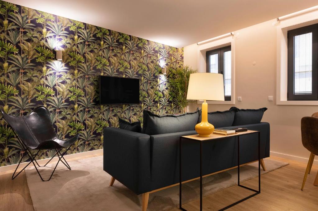 a living room with a couch and a wall mural at Palmeiras Apartment, by Bolhão Residences in Porto