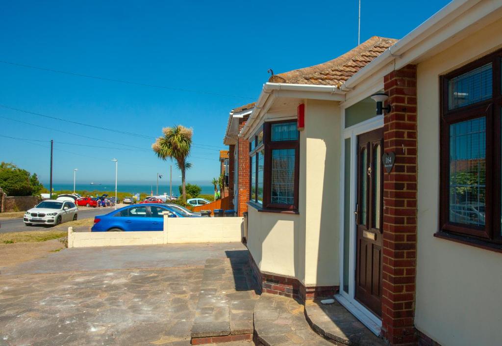 a brick building with a car parked in a parking lot at Botany Bay Holiday House - Family friendly, 50M from the beach in Kent