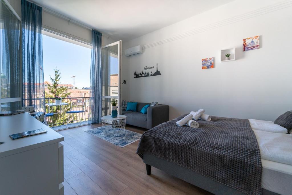 - une chambre avec un lit et une grande fenêtre dans l'établissement Sunhill Studio, à Budapest