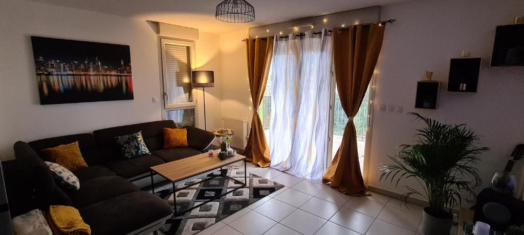 Superbe appartement COSY في مونبلييه: غرفة معيشة مع أريكة وطاولة ونافذة