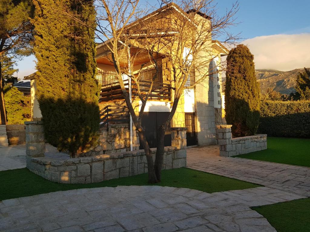 a house with a tree in front of it at For You Rentals CHALET SIERRA GUADARRAMA - LA PONDEROSA PON351 in Manzanares el Real
