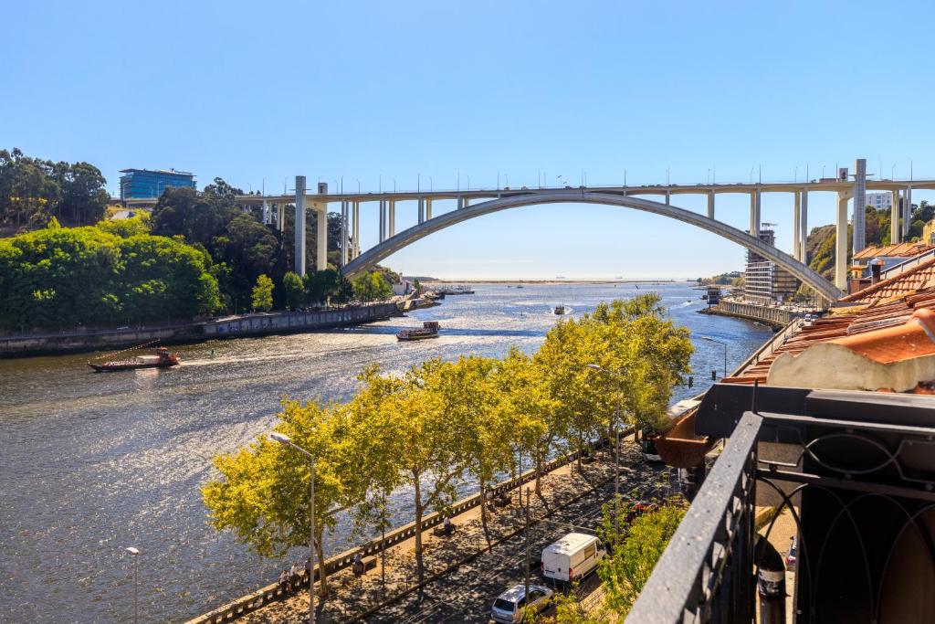 une vue sur une rivière avec un pont en arrière-plan dans l'établissement 108MM House, à Porto