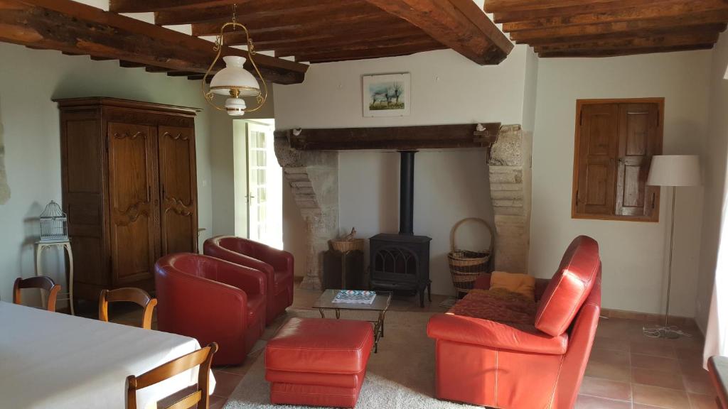- un salon avec des chaises rouges et une cheminée dans l'établissement La Bocagère d' Henri, à Saint-Côme-du-Mont