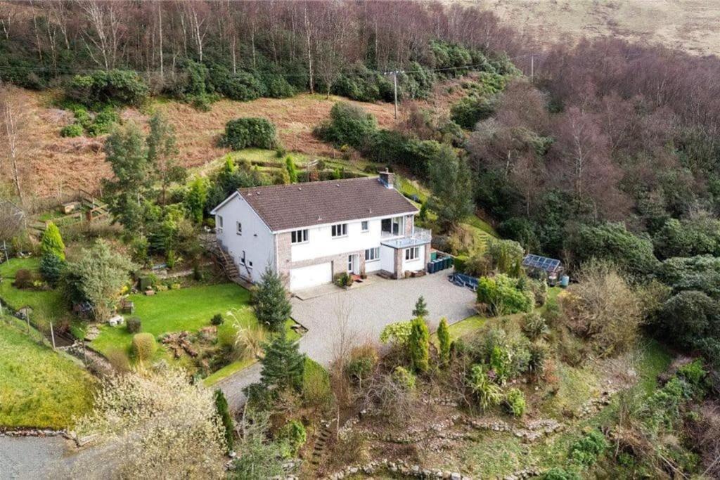 eine Luftansicht eines weißen Hauses auf einem Hügel in der Unterkunft Braemor 4 bedroom villa, all en-suite in Arrochar