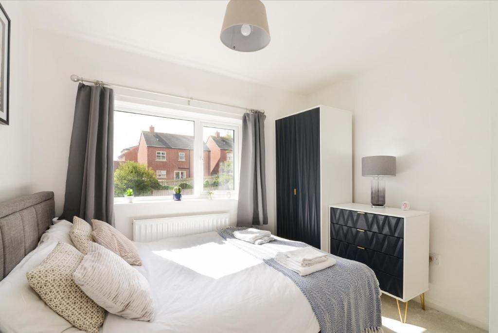 a bedroom with a bed and a large window at Alderton House - Spacious 3 Bed with Parking in Nottingham