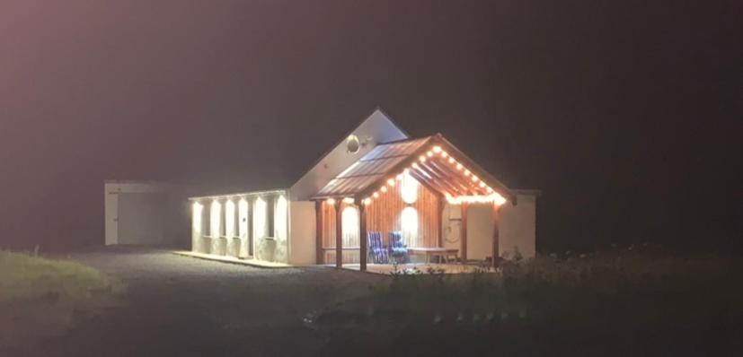 een huis verlicht 's nachts met lichten aan bij Ballygastle in Lisdoonvarna