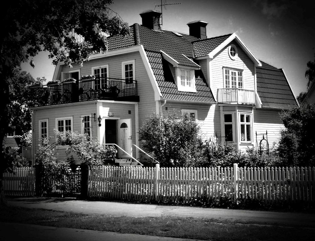 a black and white photo of a house with a fence at Villa Sol Bed & Breakfast in Borgholm