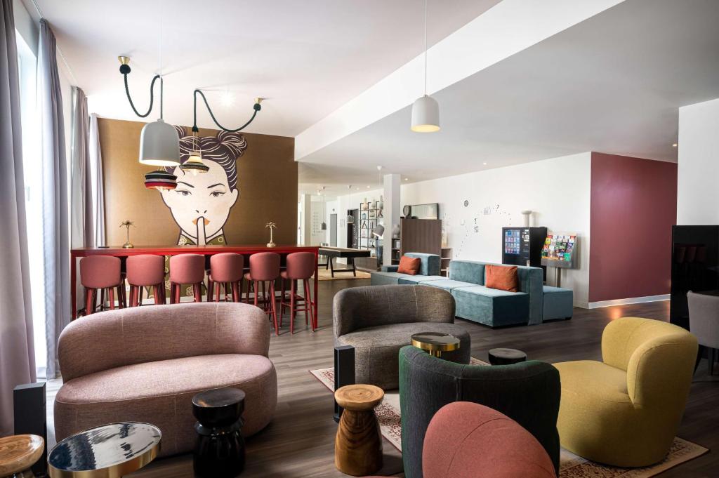 a living room with chairs and a table with a head on the wall at Arthotel ANA Amber in Rostock