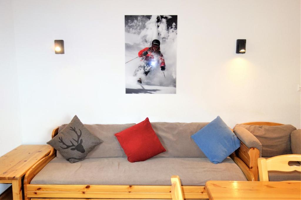 ein Sofa mit bunten Kissen darauf im Wohnzimmer in der Unterkunft Pracondu OUTDOOR & FUN appartement 2 chambres supérieur avec Balcon in Nendaz