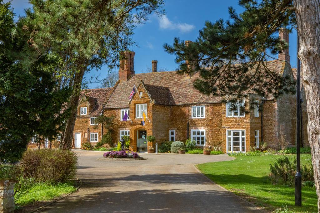 a large brick house with a driveway at Heacham Manor Hotel in Hunstanton