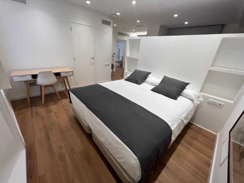 a bedroom with a large bed and a desk at Old Town Flats Casa del Bisbe in Valencia