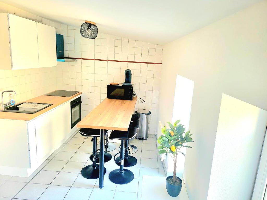 - une cuisine avec une table et deux tabourets dans l'établissement Charmant appartement 2 chambres 400 m centre gare, à Valence