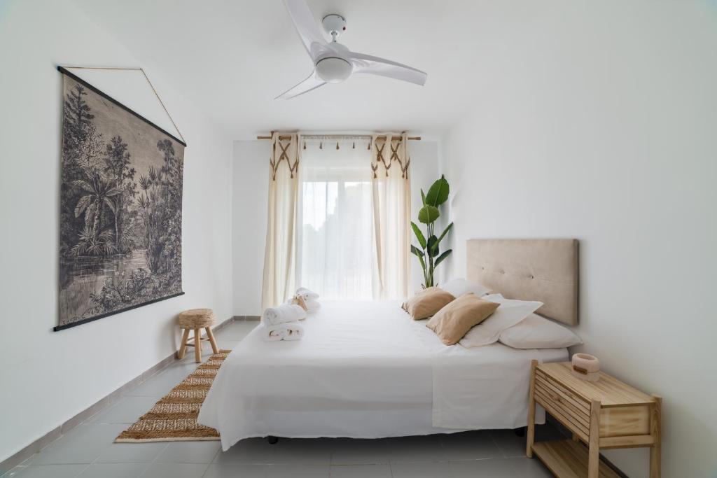 een witte slaapkamer met een groot bed en een raam bij Chalet con piscina en entorno idílico in La Zubia
