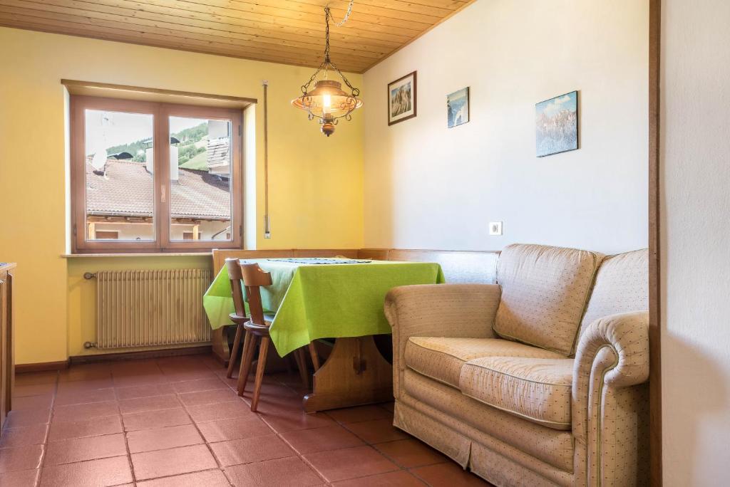 sala de estar con mesa verde y sofá en Pension Sonia App 104 en Funes