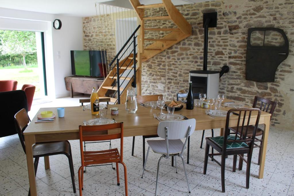 una sala da pranzo con tavolo e sedie in legno di Gîte Le Coq Au Vert en Suisse Normande a Hamars