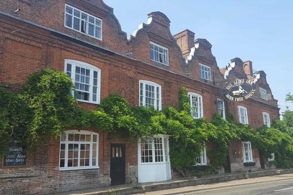 a brick building with a clock on the side of it at Scole Inn Hotel in Diss