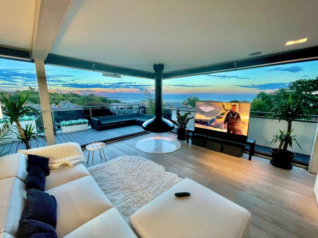 ボーンマスにあるThe Beach Hytte - Stunning Sea View Penthouseの白いソファとテレビのあるリビングルーム