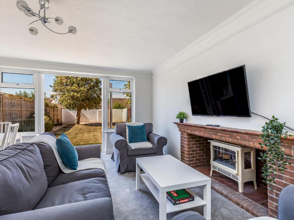 a living room with a fireplace and a tv at Pass The Keys Lovely Ground Floor Flat With Large Garden in Chichester