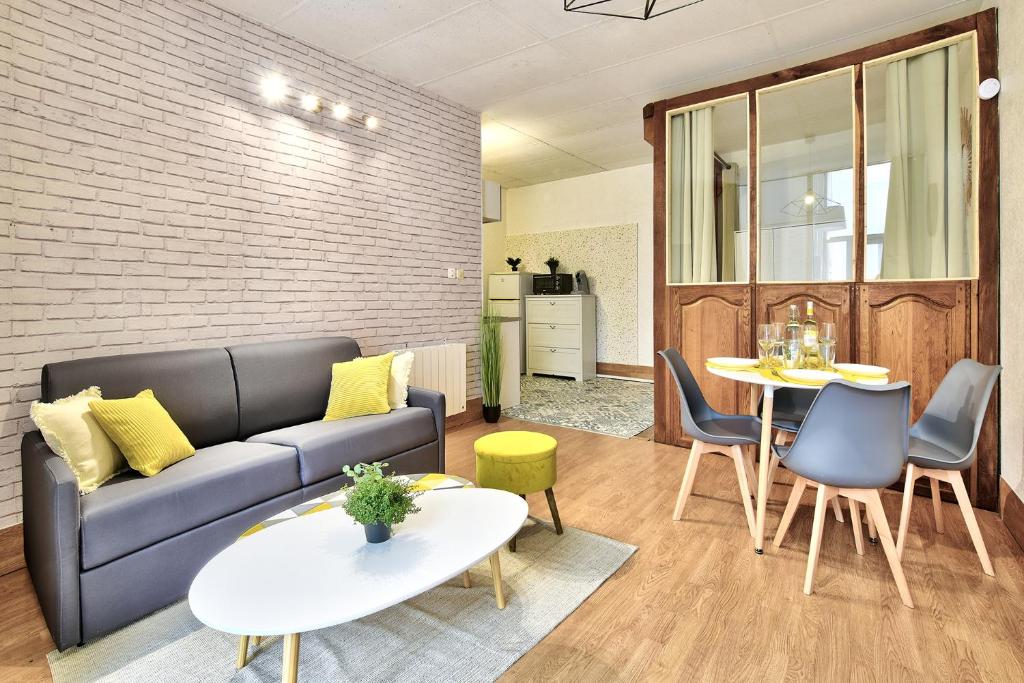 a living room with a couch and a table at Appartement L'Elégant Chalonnais - Hyper-Centre in Chalon-sur-Saône