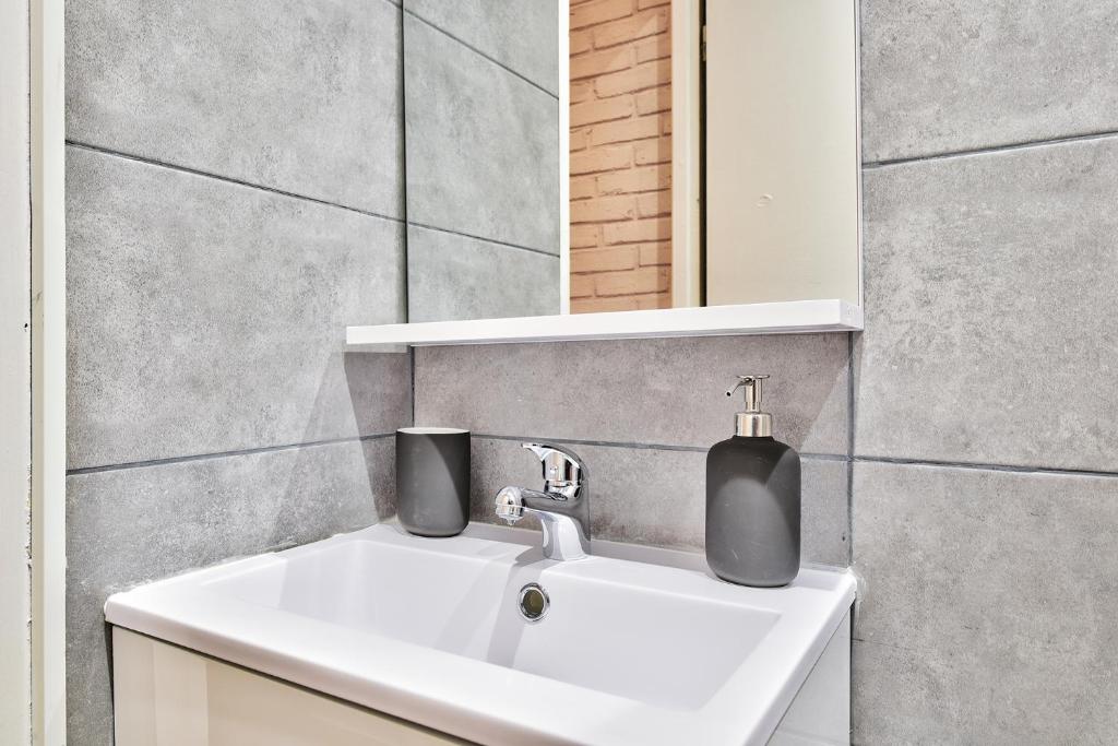 a bathroom sink with a soap dispenser on it at Appartement L&#39;Elégant Chalonnais - Hyper-Centre in Chalon-sur-Saône
