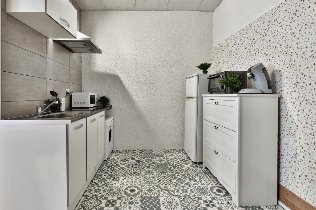 a small kitchen with white appliances and a tile floor at Appartement L&#39;Elégant Chalonnais - Hyper-Centre in Chalon-sur-Saône