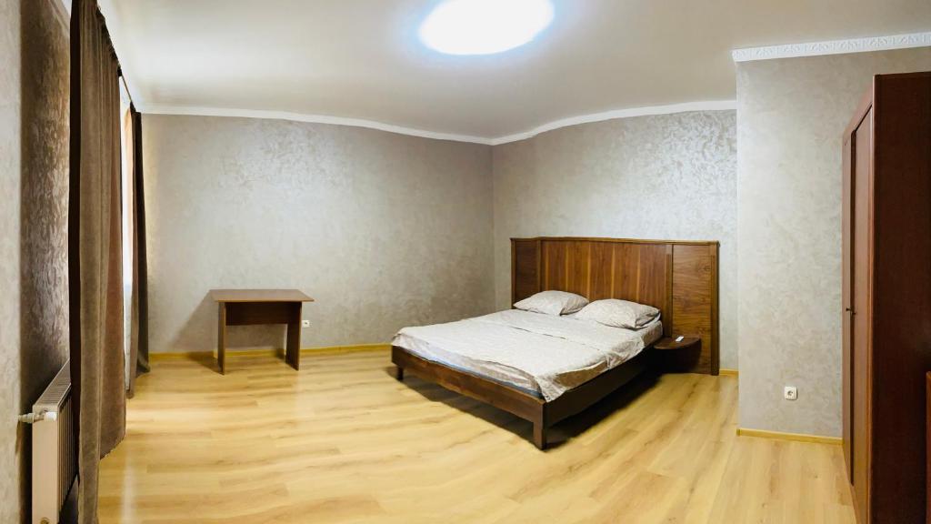 a bedroom with a bed and a table in it at Ogienka 2b, Center Lutsk in Lutsk