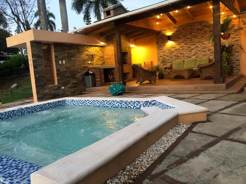 a swimming pool in front of a house at Villa Altos del Pedregal in Jarabacoa