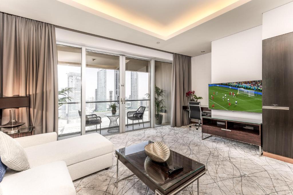 a living room with a tv and a couch at Kempinski residences-previously The Address Dubai mall in Dubai