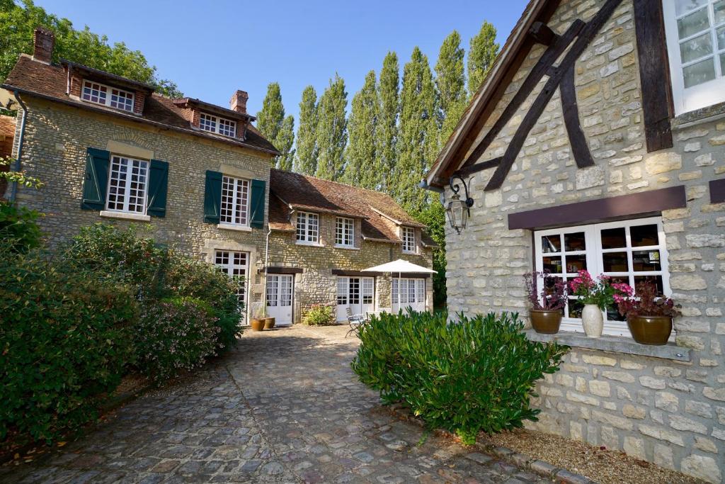 ein Steinhaus mit Topfpflanzen nebeneinander in der Unterkunft Le Domaine du Moulin Foulon in Essay