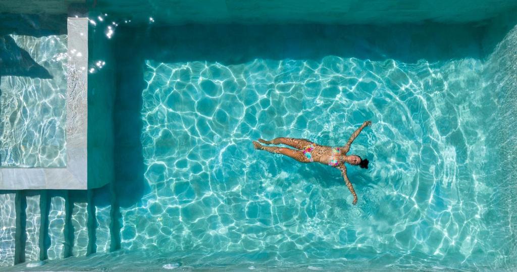 una persona nadando en una piscina en Fairytale Villas, en Suda