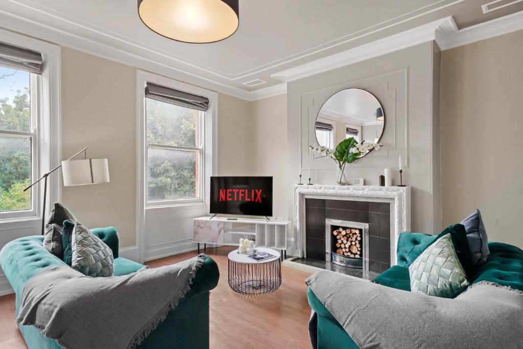 a living room with two couches and a fireplace at Stunning Georgian Apartment In Yorkshire - Parking in Wakefield