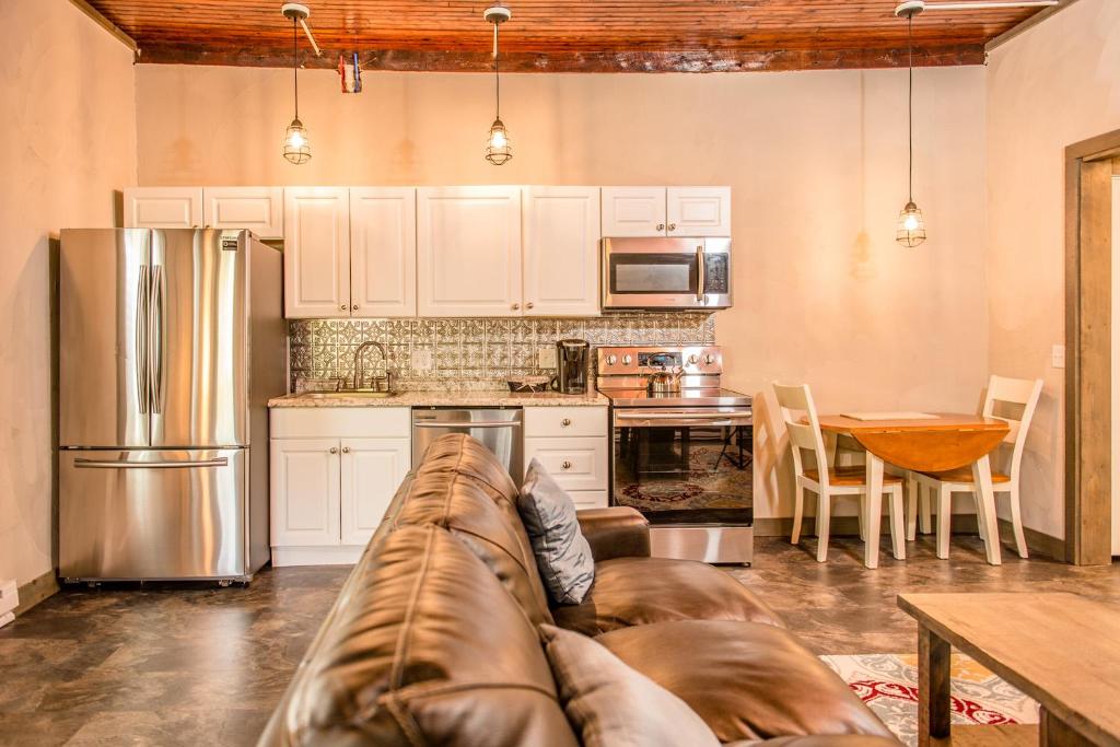 a living room with a couch in a kitchen at Strictly Moose Luxury Vacation Suites in Gorham