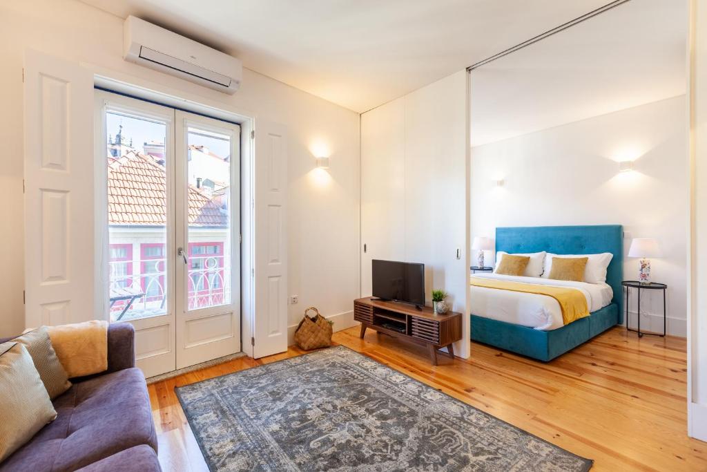 a bedroom with a bed and a couch and a tv at D&S - Porto São Bento Apartments III in Porto