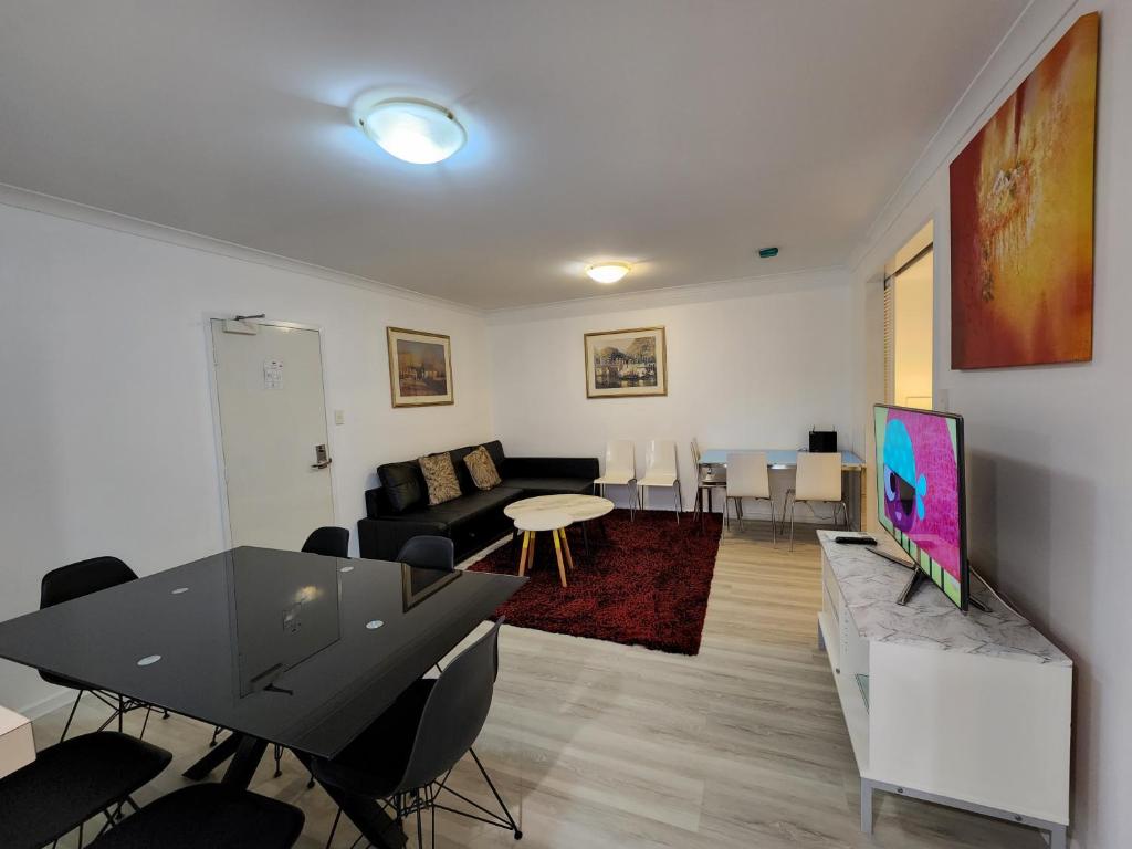 a living room with a couch and a table with chairs at PERTH CBD APARTMENTS in Perth