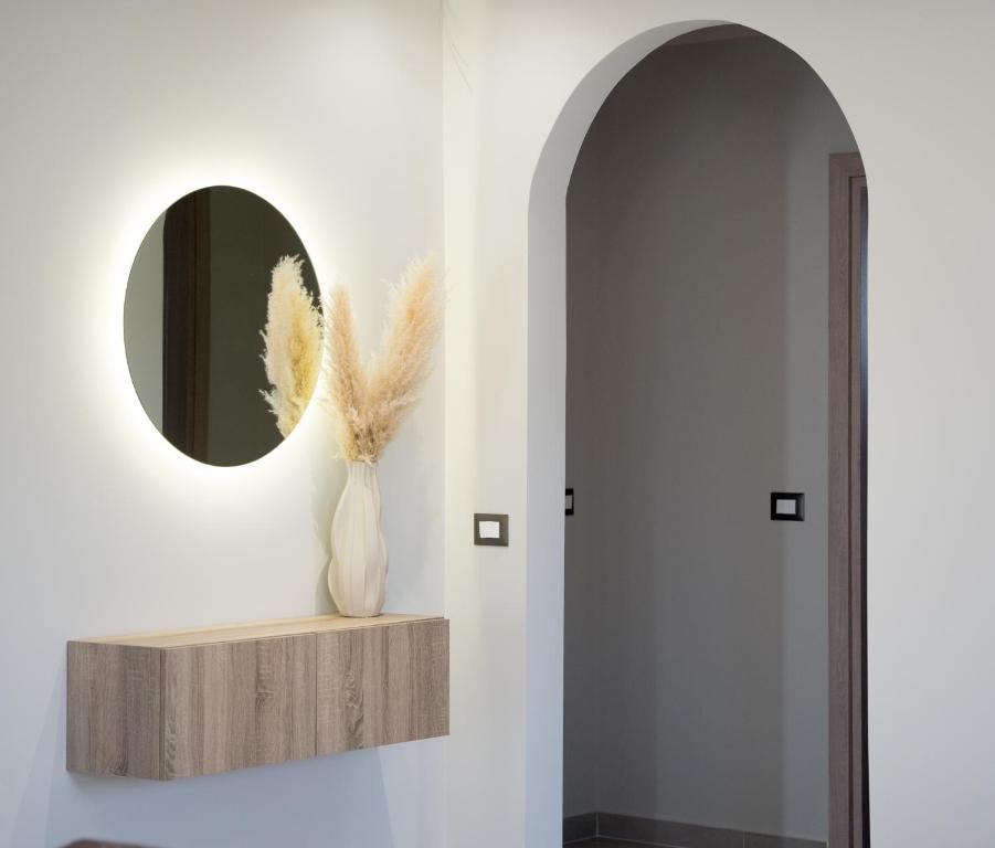 a hallway with a mirror and a vase with feathers at Villa Vrahinari in Kounopetra